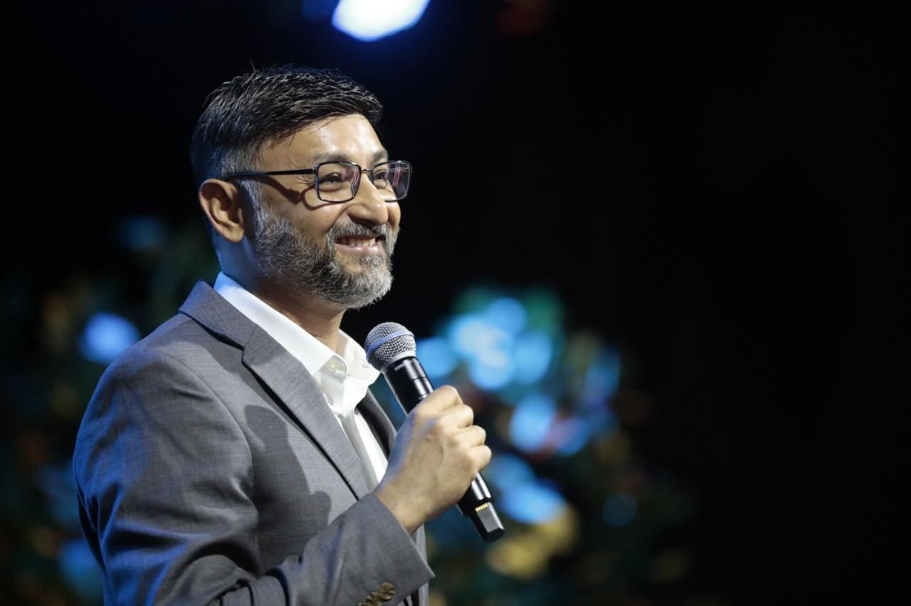 Líder falando ao microfone durante um evento